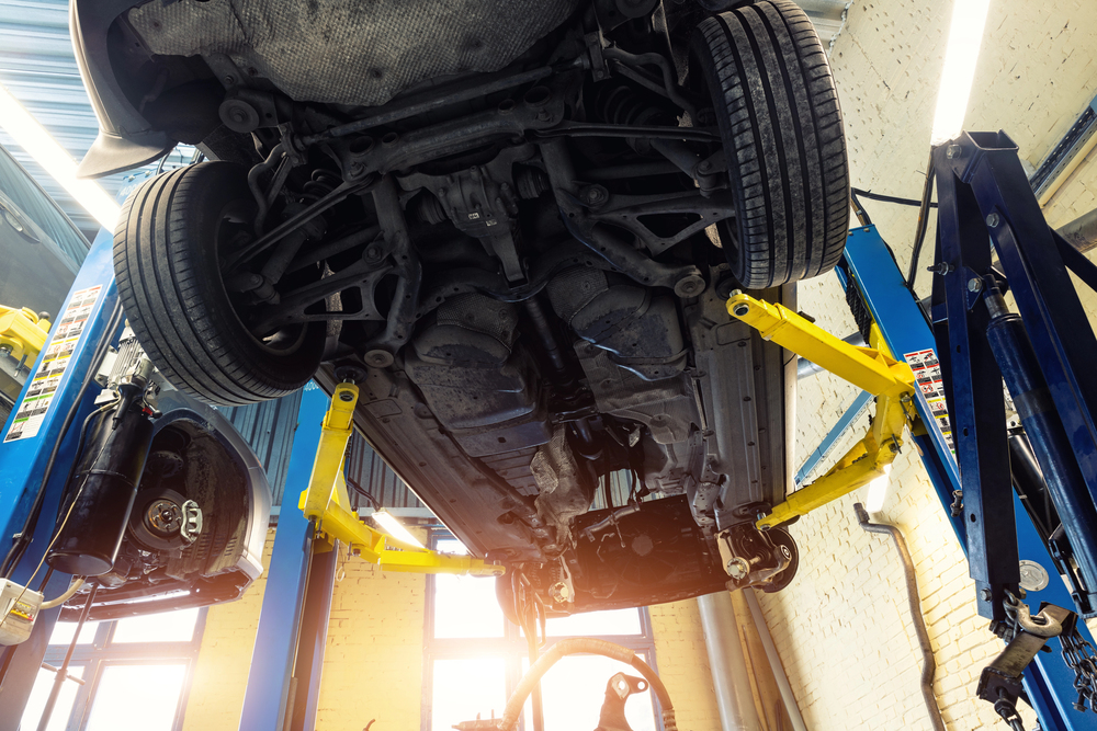 Looking up at the structure of a vehicle on a lift.