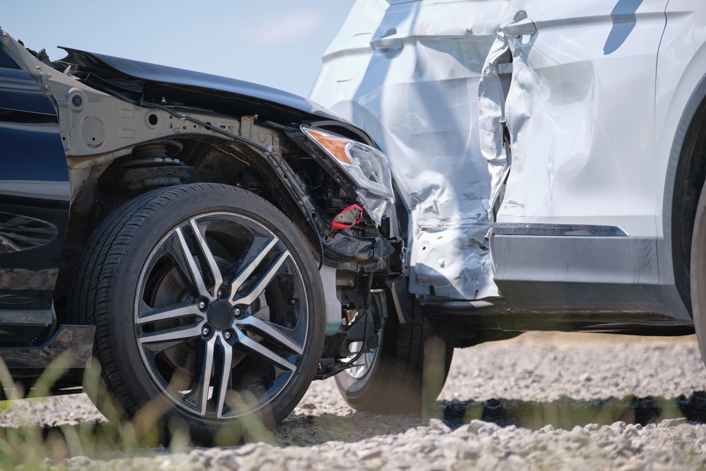 A side-impact collision between a black car and a white car.