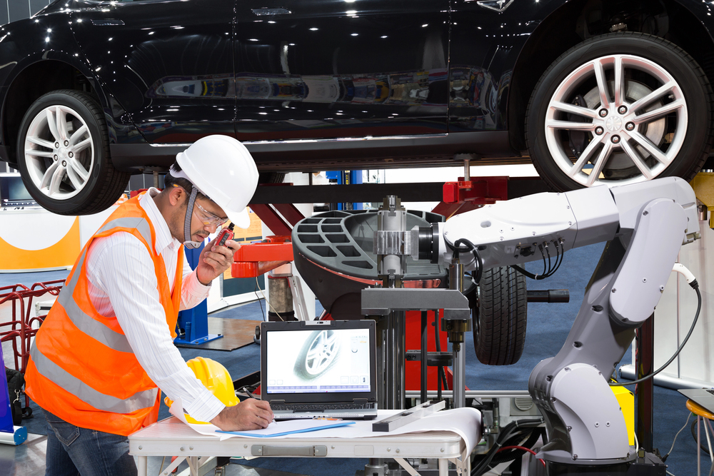 An automotive technician setting up laser measuring.