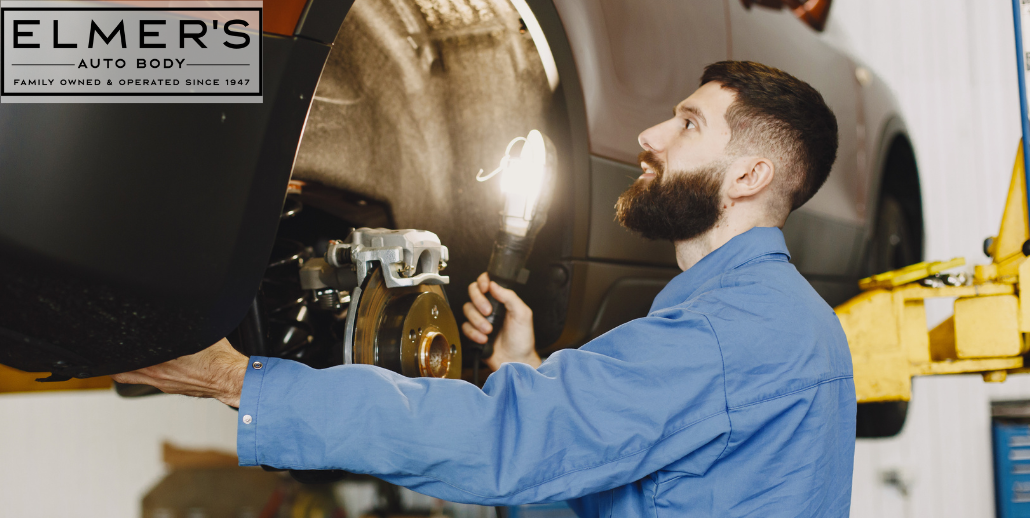 An auto body technician conducts a post-repair inspection.